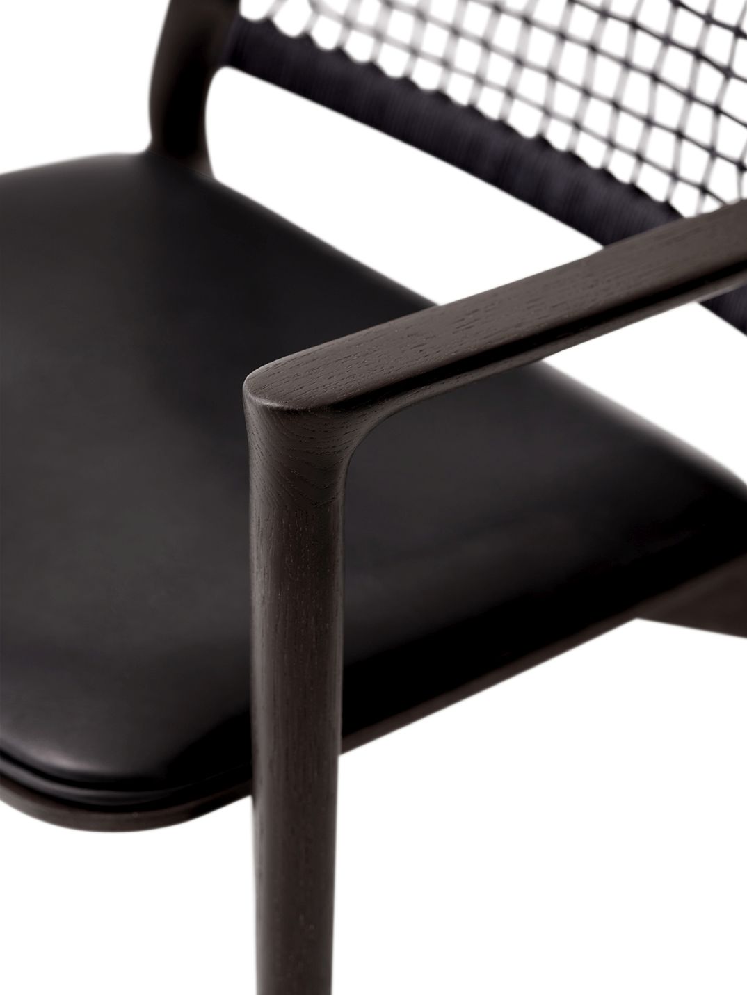 Detailaufnahme des Vipp Cabin Lounge Stuhls: Schwarzer Holzrahmen, Ledersitz und geflochtene Rückenlehne.