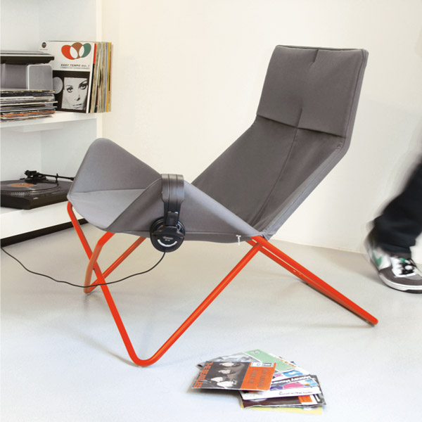 Grauer In-Out Sessel von Richard Lampert mit rotem Gestell und Kopfhörern. Design Sessel für Indoor.