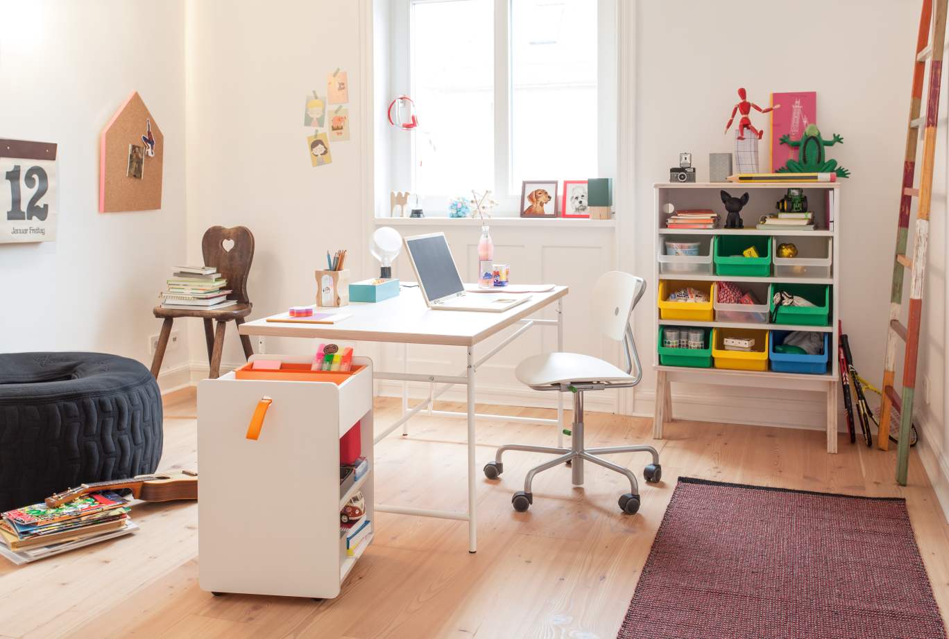 Kinderzimmer mit weißem Richard Lampert Container, Schreibtisch, Stuhl und Spielzeugregal für Ordnung und Aufbewahrung.