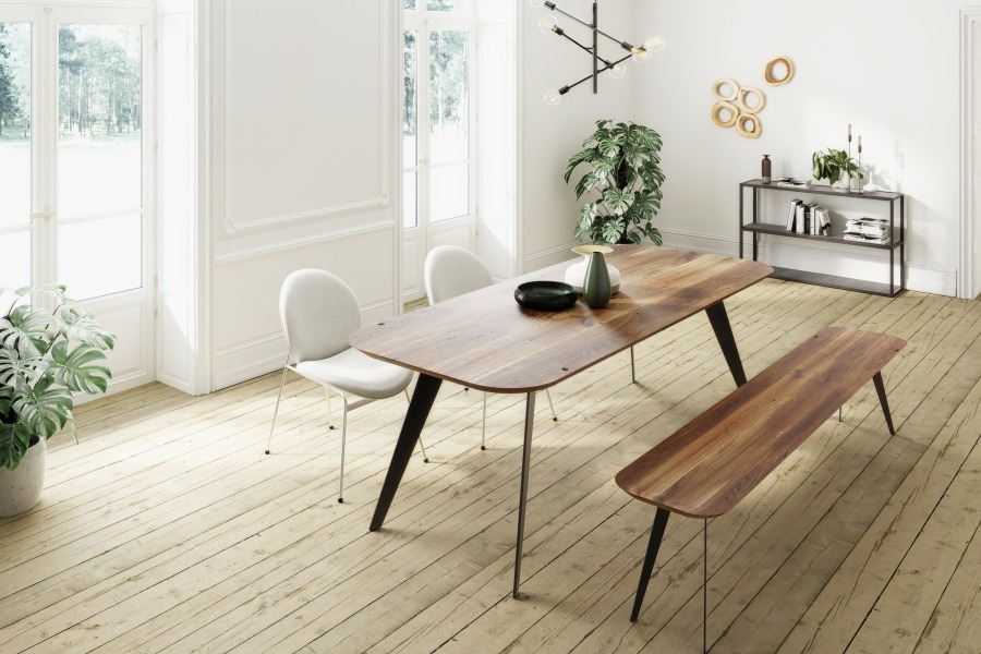 Enke Esstisch Trebord aus Holz mit passender Bank und Stühlen in hellem Raum.