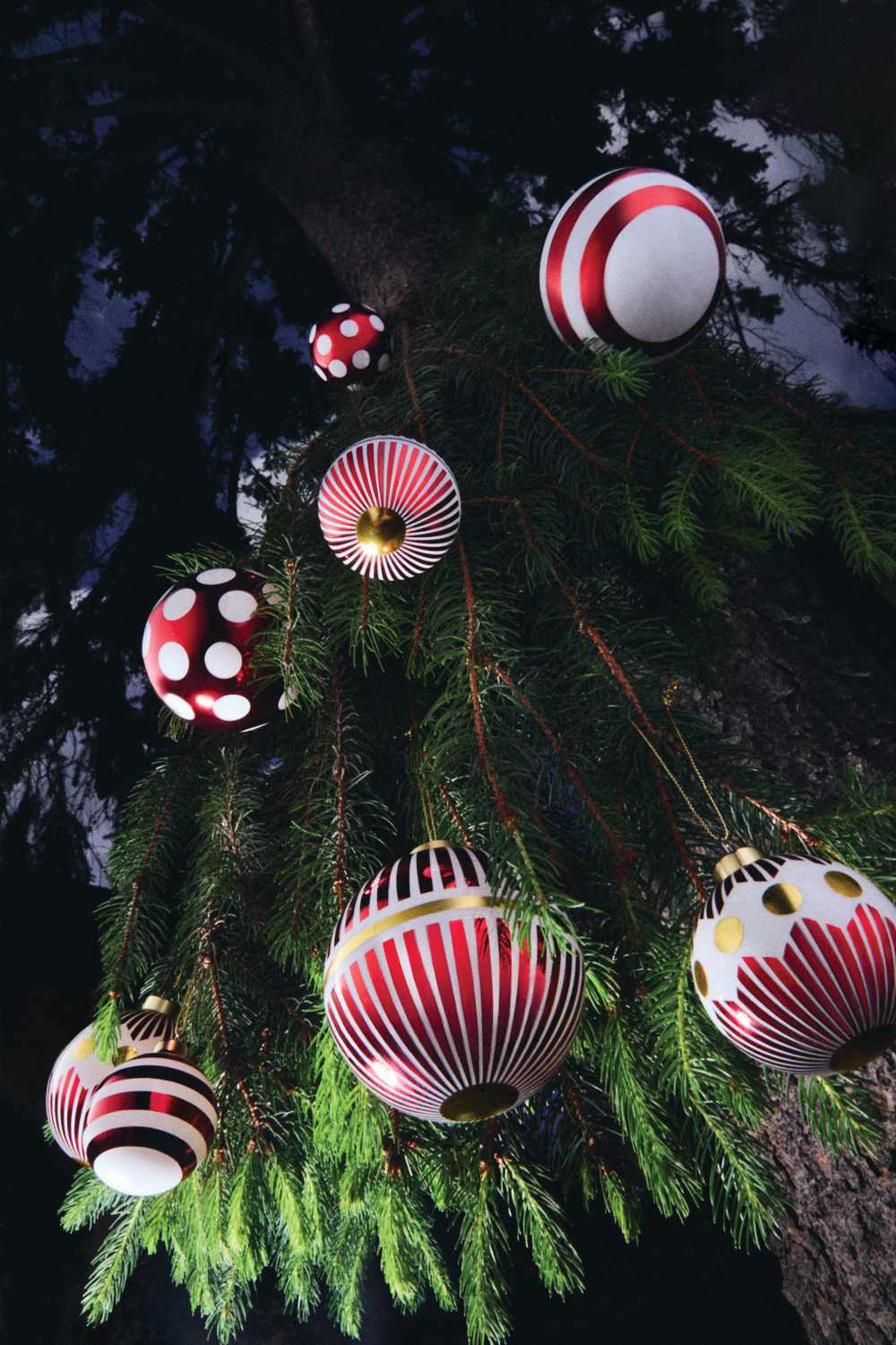 Nahaufnahme von Alessi Weihnachtskugeln NZ04 1 Delight in Rot und Weiß am Weihnachtsbaum.