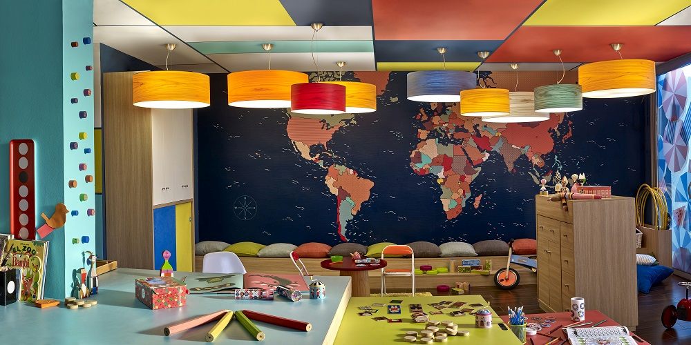 Bunte Gea LED Pendelleuchten von LZF Lamps in einem farbenfrohen Kinderzimmer mit Weltkarte.
