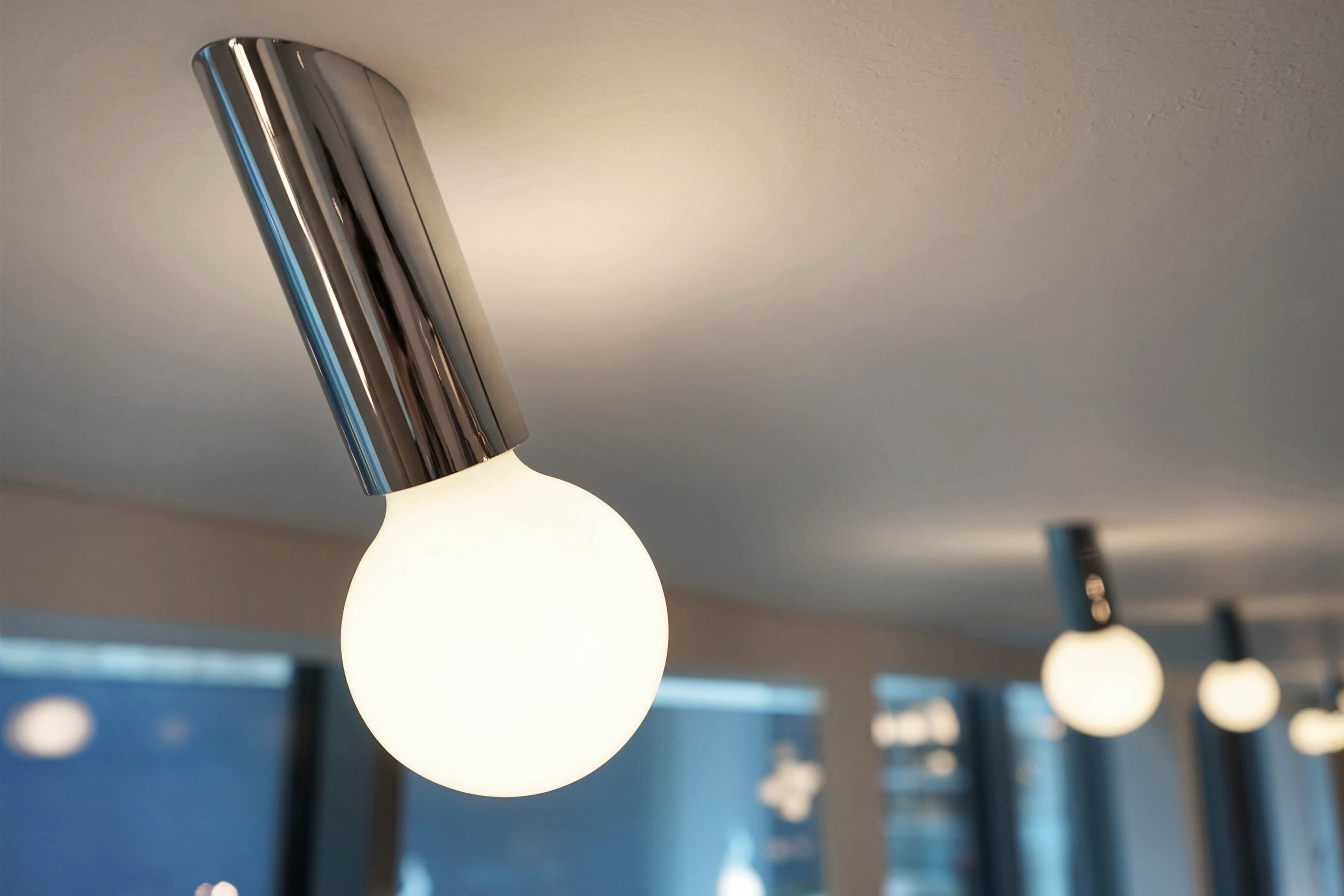 DNA Leuchte: Moderne Deckenleuchte mit Chrom-Halterung und runder, leuchtender Glühbirne. Design Lampe für Wohnraum.