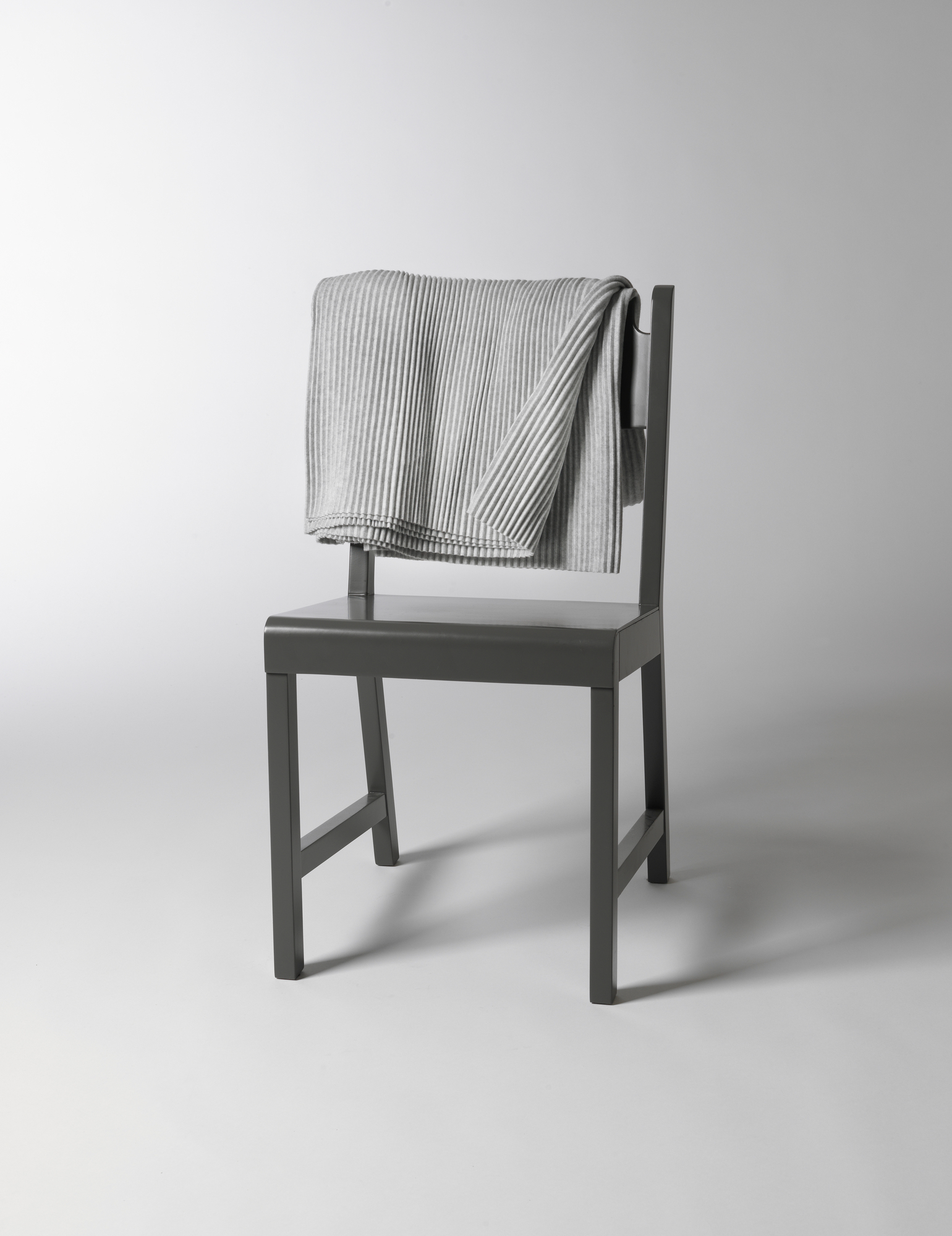 Helle Pleece Throw Decke von Design House Stockholm, hellgraue Kuscheldecke auf einem Stuhl.