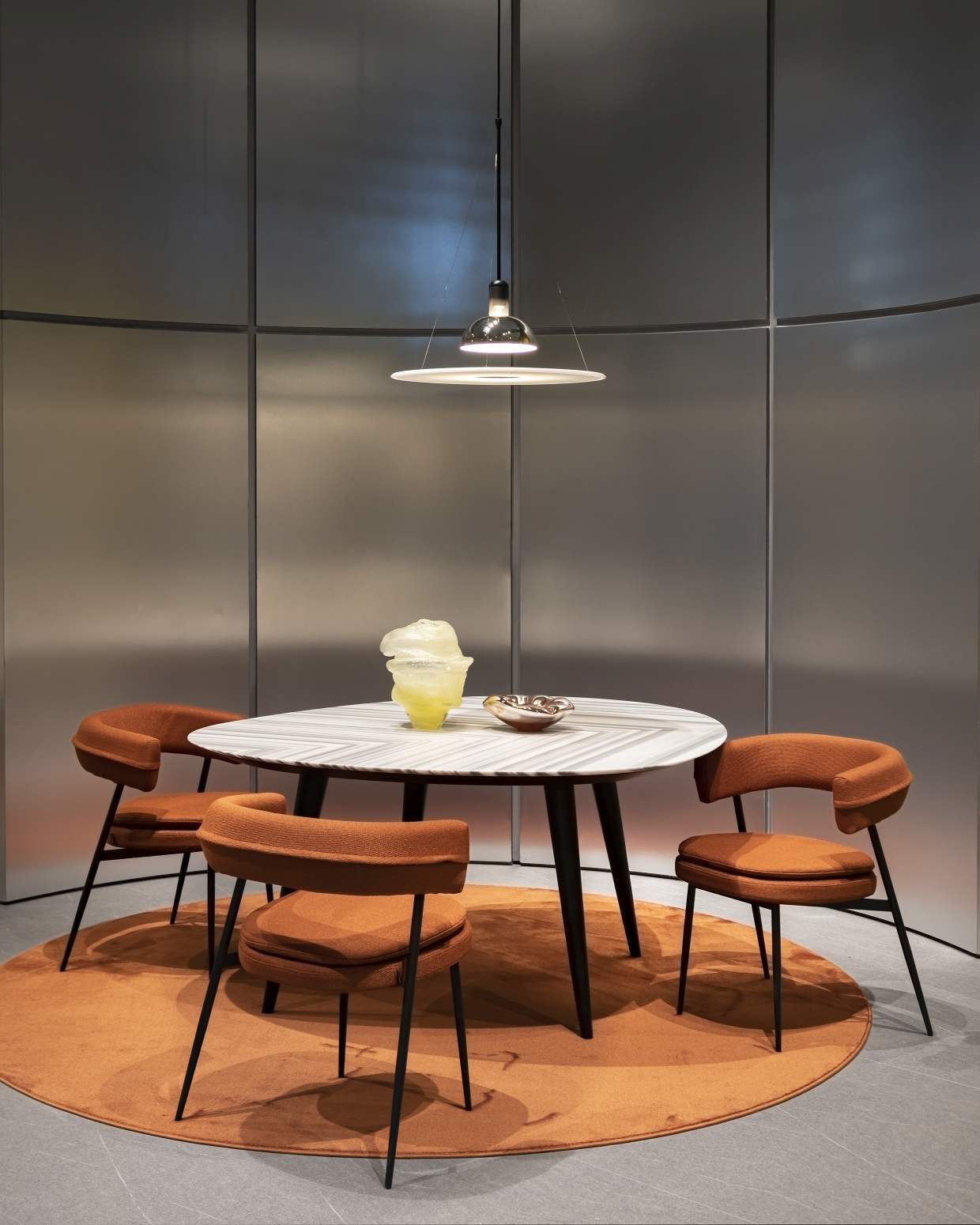 Zanotta Esstisch 2318 Tweed Marble, 160 cm, mit Stühlen und Dekoration auf einem runden Teppich.