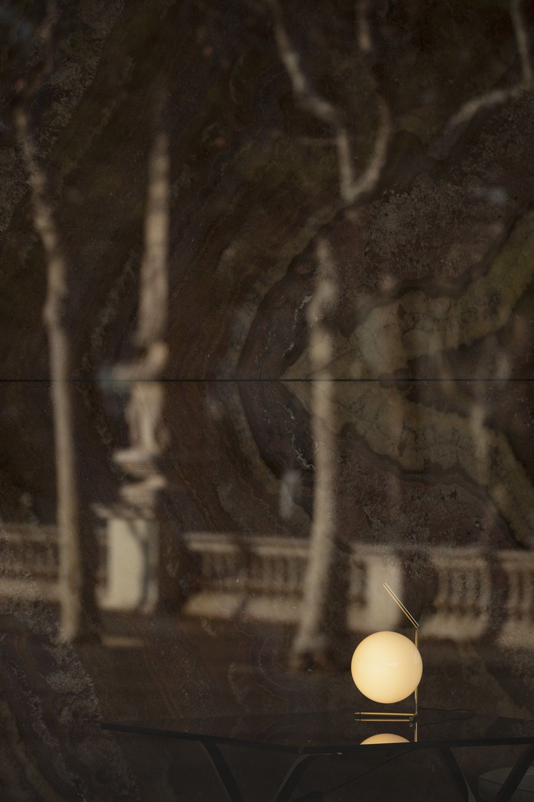 Nahaufnahme der Flos IC T1 Tischleuchte in Gold mit einer runden, weißen Glaskugel.