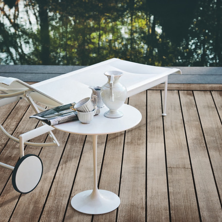 Weiße Richard Schultz Outdoor Liege und Beistelltisch auf Holzterrasse mit Blick auf Wasser.