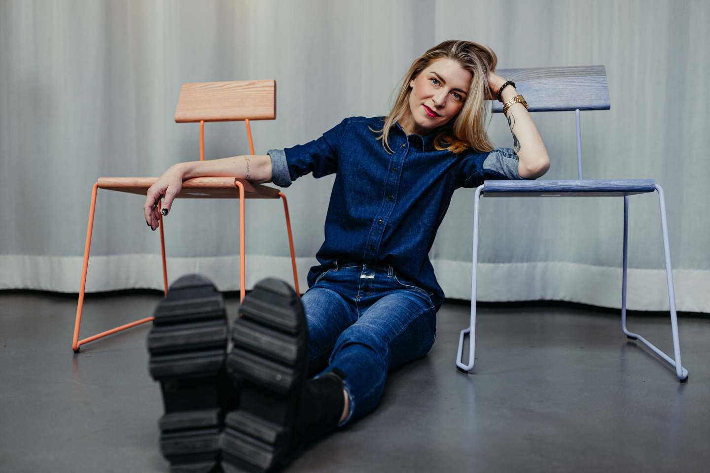 Frau lehnt an D:005 Stühlen von Fuchs & Habicht, Design Stühle in Weiß und Orange.