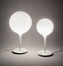 Zwei weiße Castore Tischleuchten von Artemide mit runden Lampenschirmen spenden warmes Licht.