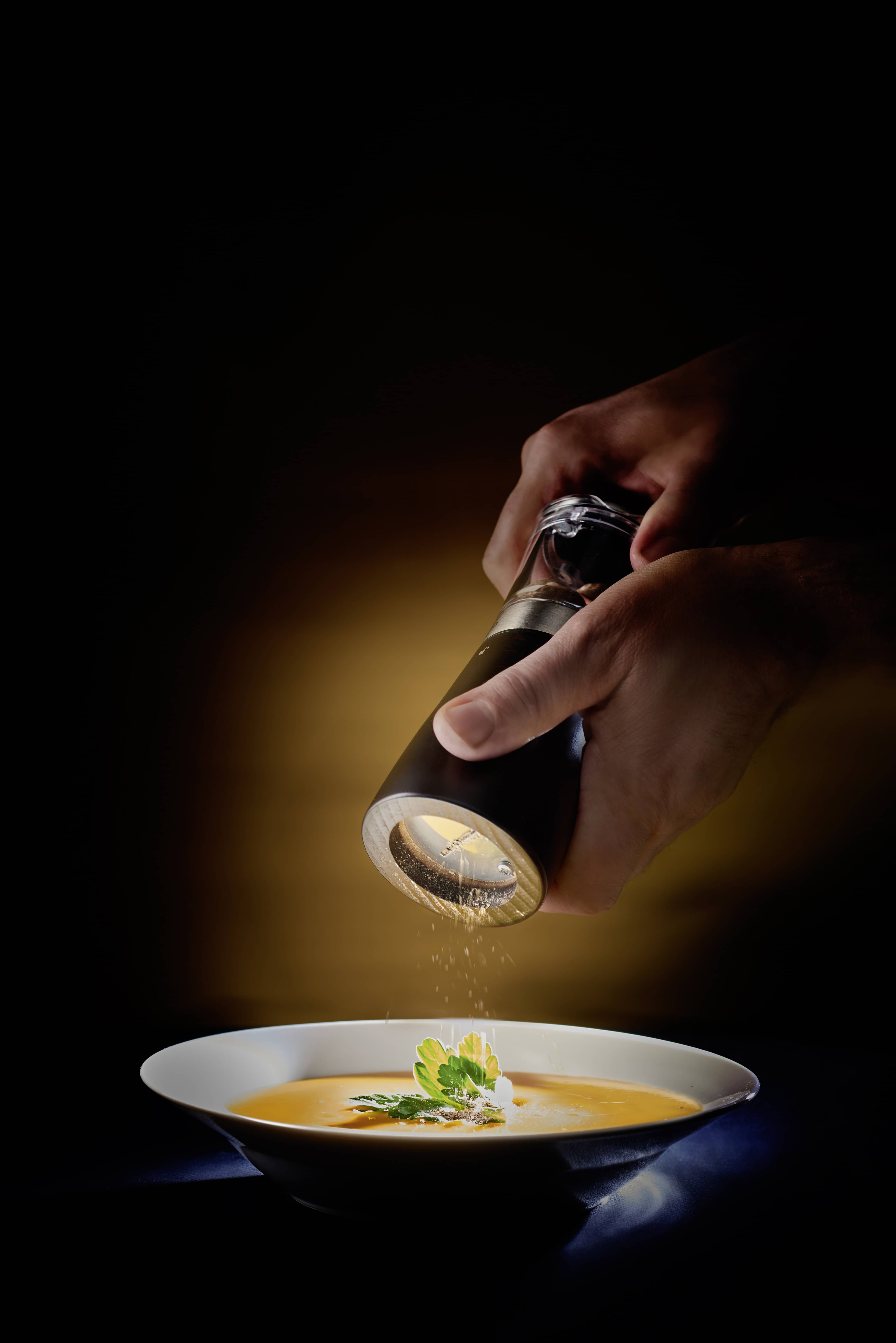 Daman Muskatmühle Peugeot: Hände mahlen Muskatnuss über einer Suppe. Gewürzmühle aus Holz und Acryl.