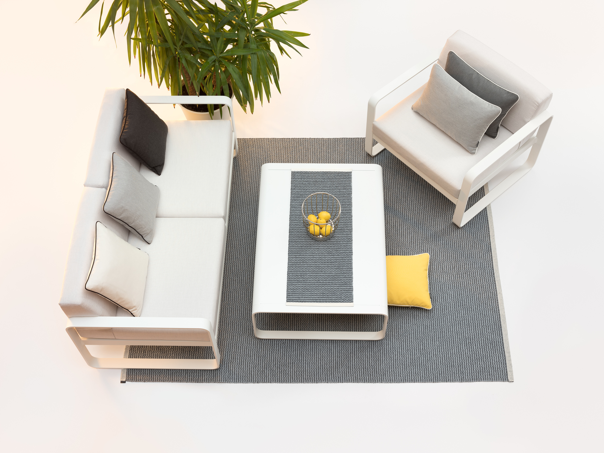 Pappelina Mono Teppich 140x200 cm in Grau, mit Möbeln und Pflanze auf weißem Hintergrund.