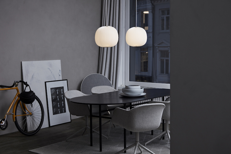 Zwei Lamella Pendelleuchten von Le Klint über einem Esstisch in modernem Wohnraum.