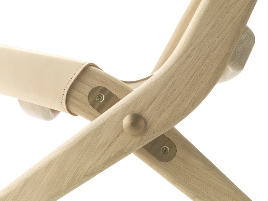 Detailaufnahme des Saxe Chair von Audo: Holzrahmen mit Lederdetails und Messingbeschlägen. Designstuhl für modernes Wohnen.