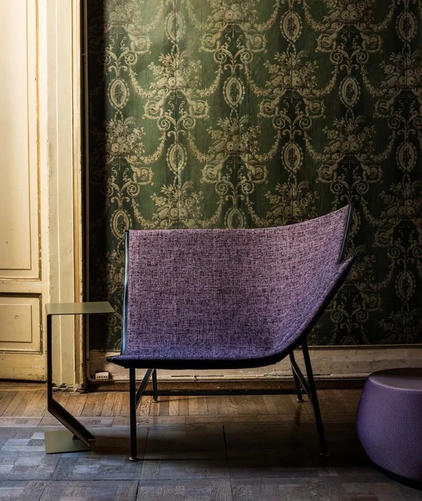 Mark Table Beistelltisch von Moroso neben einem lila Sessel auf einem Holzboden.