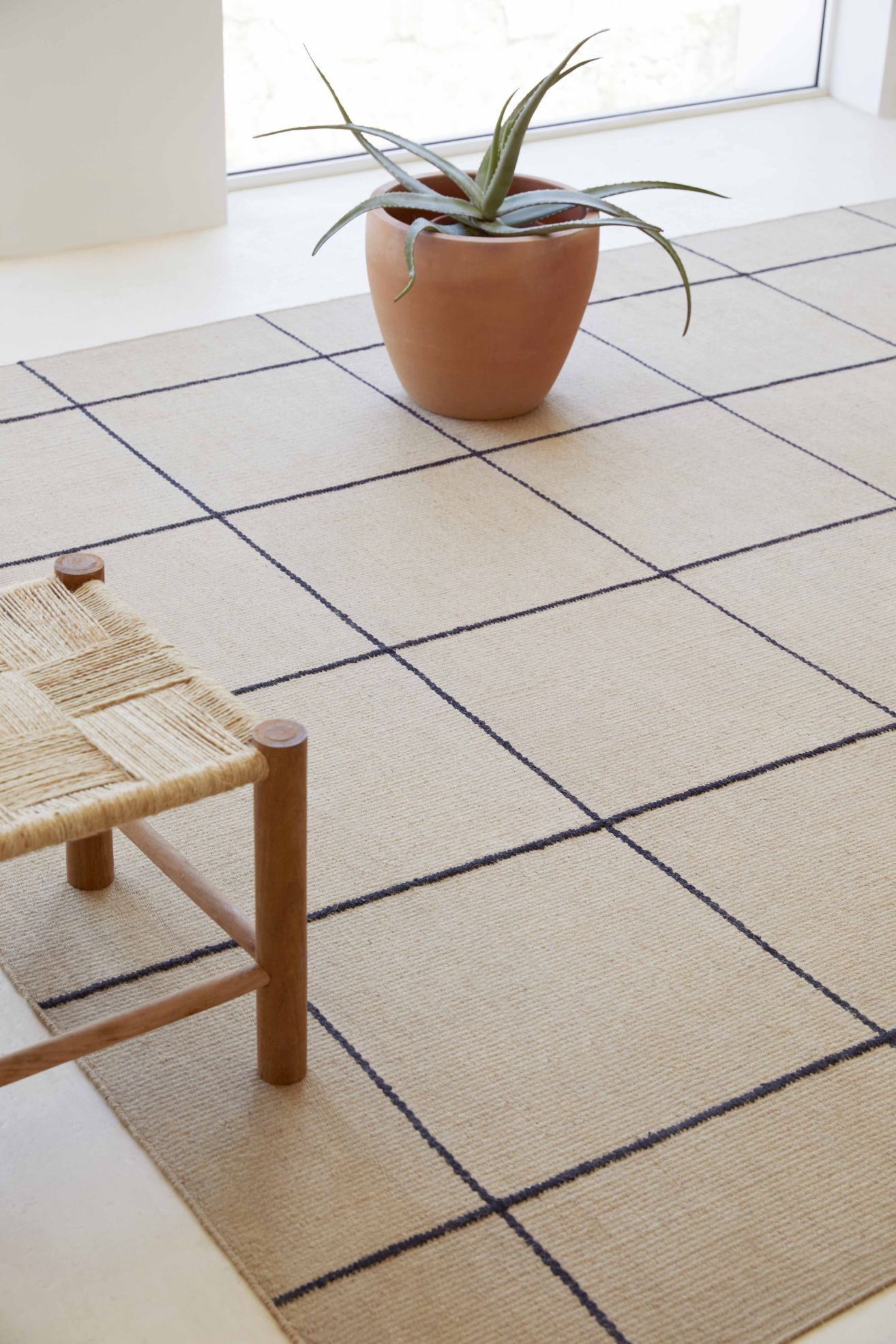 Roots Teppich mit grafischem Muster in Beige und Dunkelblau, natürlicher Look für Wohnzimmer und Schlafzimmer.