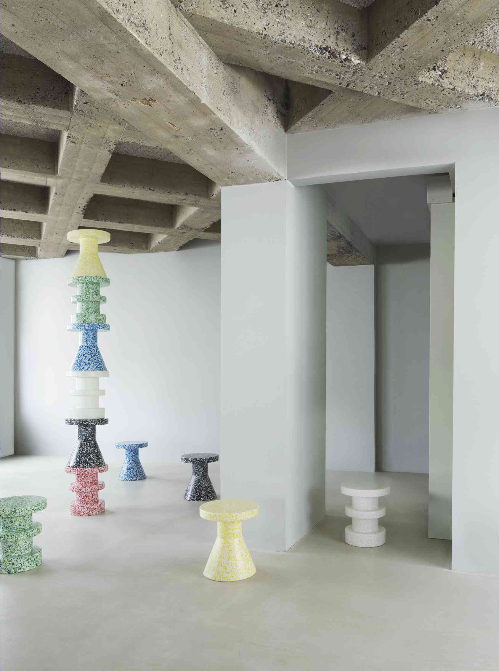 Mehrere bunte Bit Stool Cone Hocker von Normann Copenhagen in einem minimalistischen Raum.