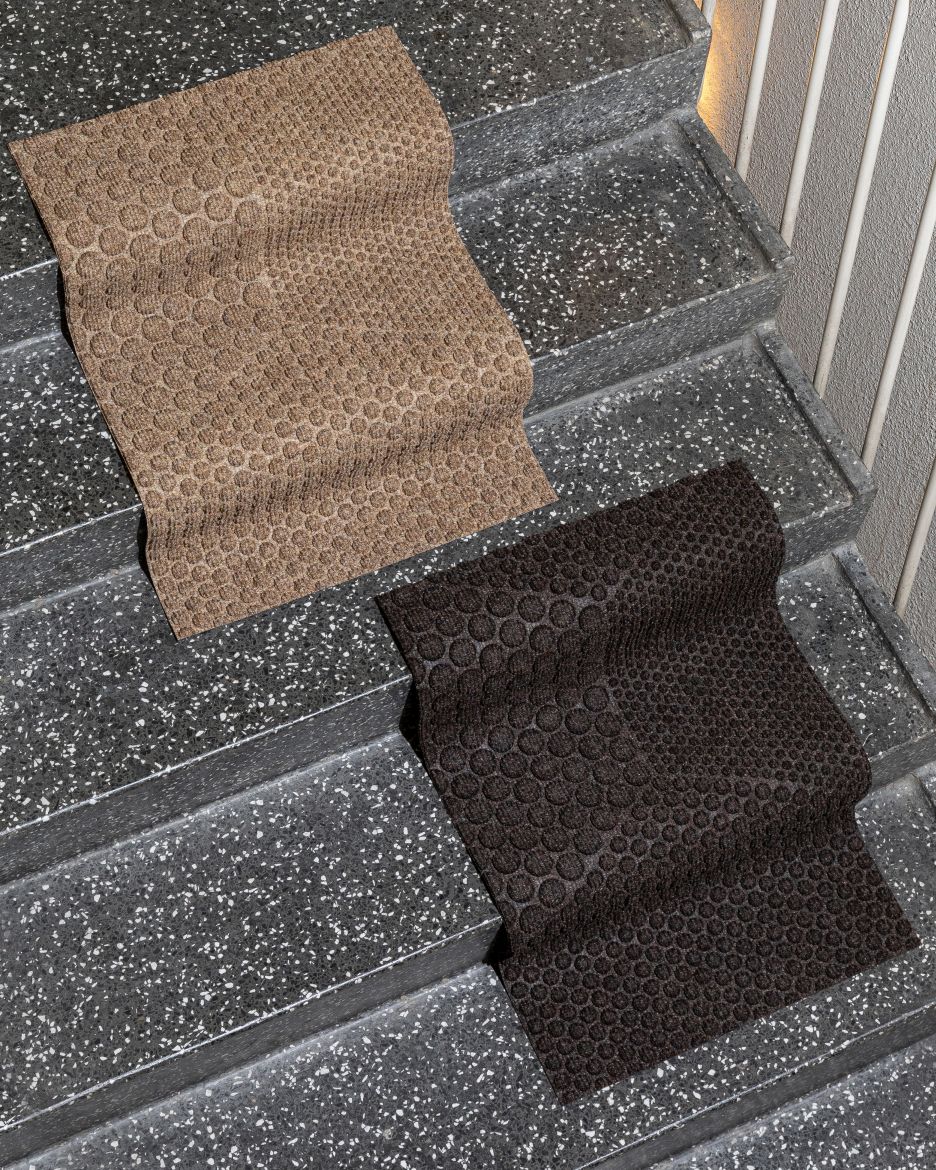Zwei Hex Fußmatten Desert von Heymat auf einer Treppe, beige und braun, mit Wabenmuster.