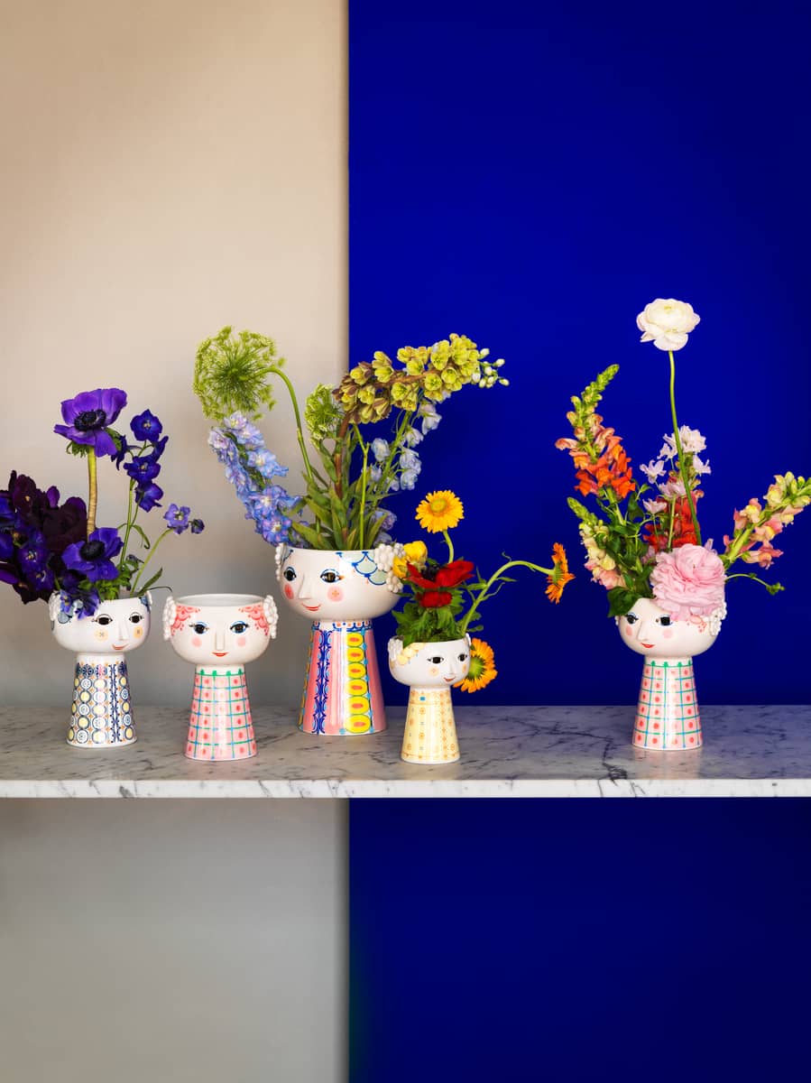 Fünf dekorative Eva Vasen von Bjorn Wiinblad, gefüllt mit bunten Blumen, auf einem Marmortisch.