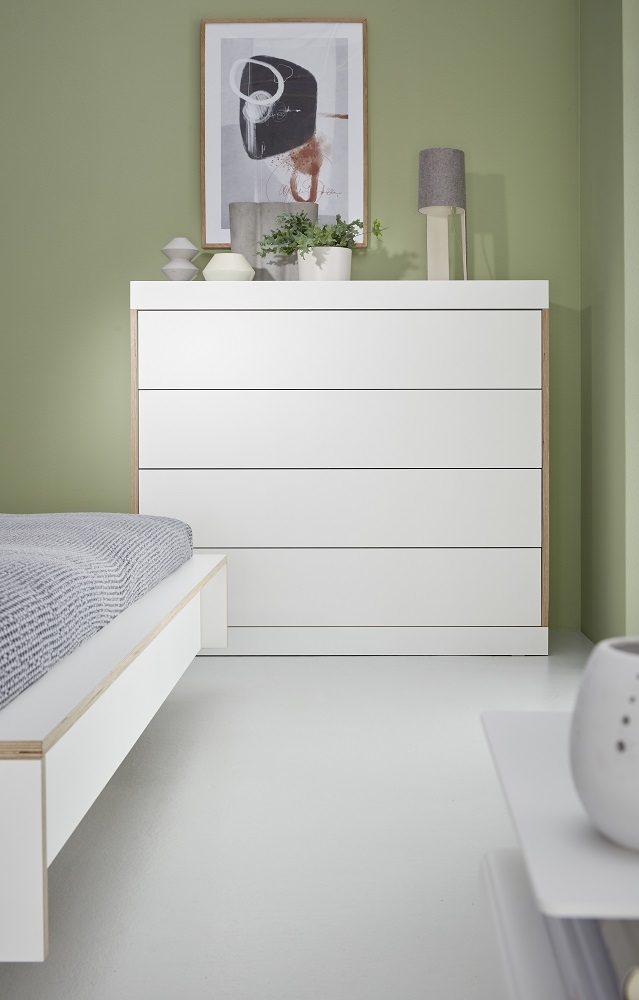 Weiße Flai Kommode von Müller Möbelwerkstätten mit vier Schubladen im Schlafzimmer.