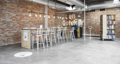 Reihe von weißen Emeco Navy Barhocker Barstühlen an einem Tresen in einem Raum.