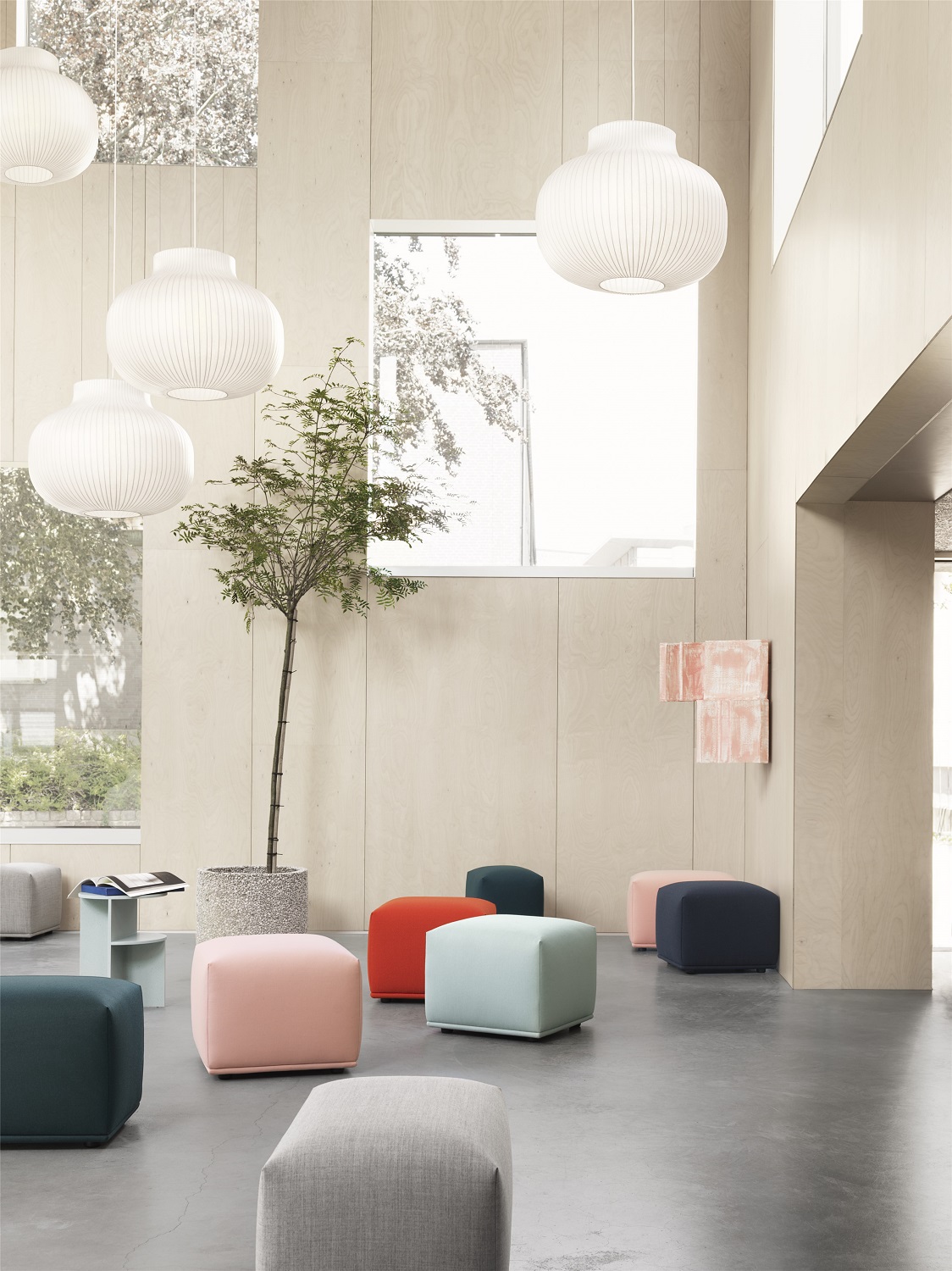 Innenraum mit farbenfrohen Echo Pouf Hockern von Muuto, moderne Sitzmöbel für Wohnzimmer und Büro.