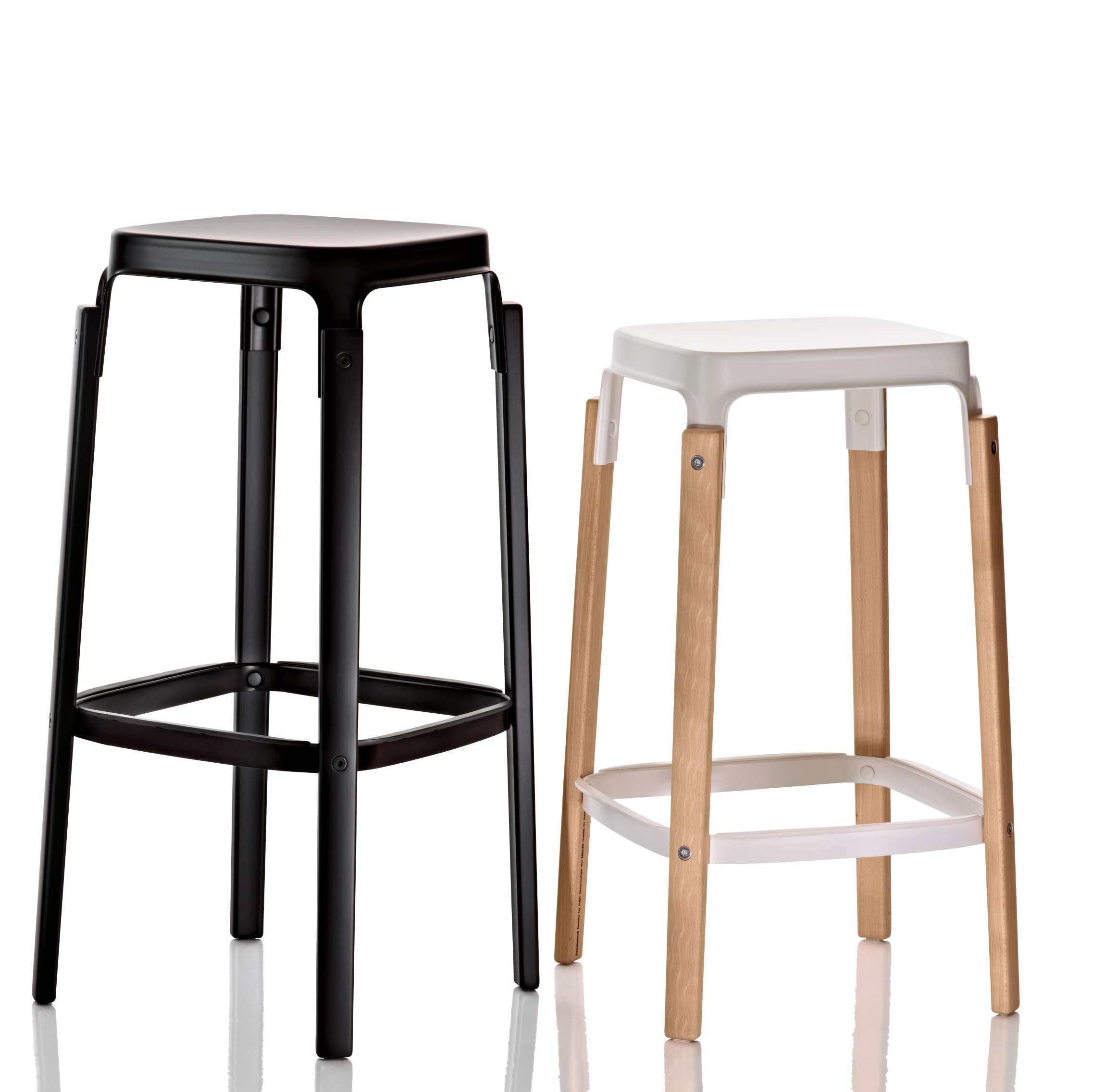 Zwei Steelwood Hocker von Magis, einer schwarz, einer weiß mit Holzbeinen.