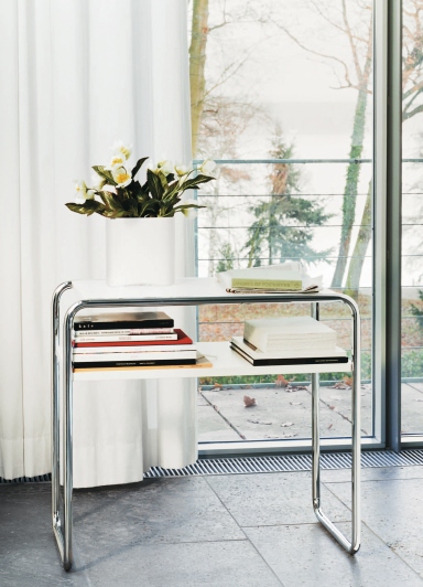 Thonet B 9 d/1 Beistelltisch mit Fachboden, Stahlrohr und weißen Ablageflächen, Bücher und Dekoration.