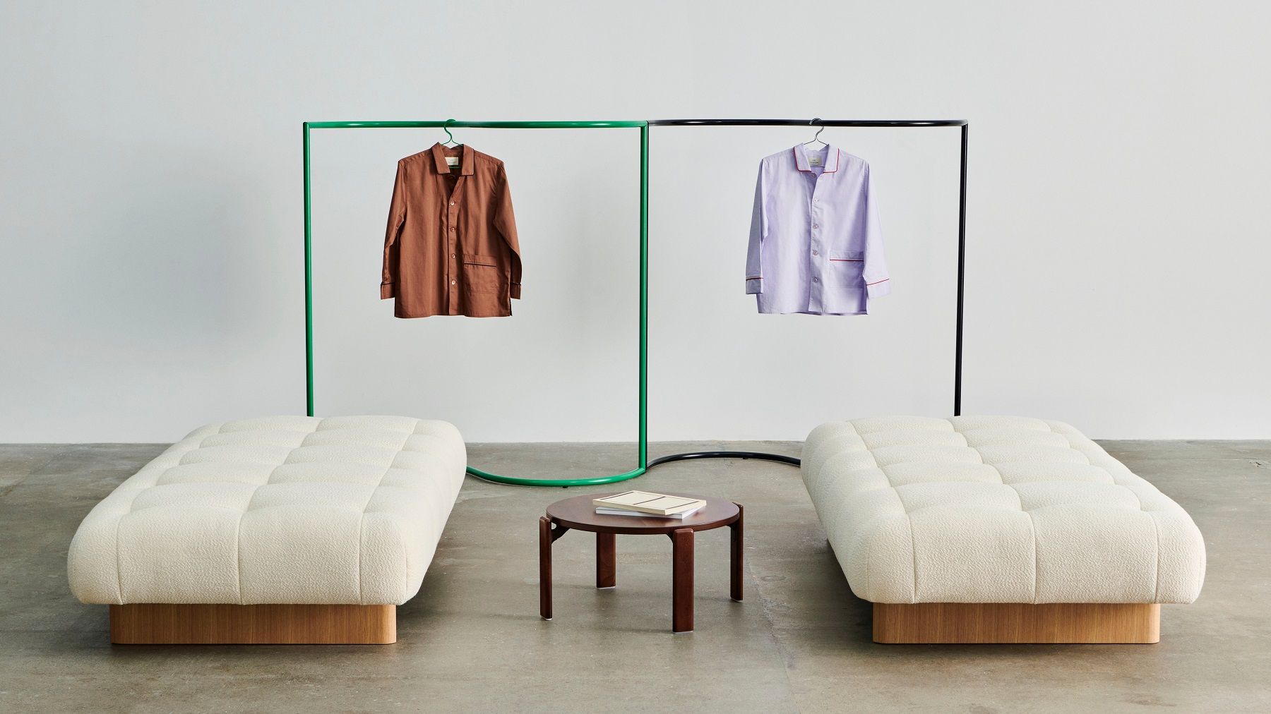 Zwei Quilton Daybeds von Hay mit Kleiderständern und einem Beistelltisch in einem minimalistischen Raum.