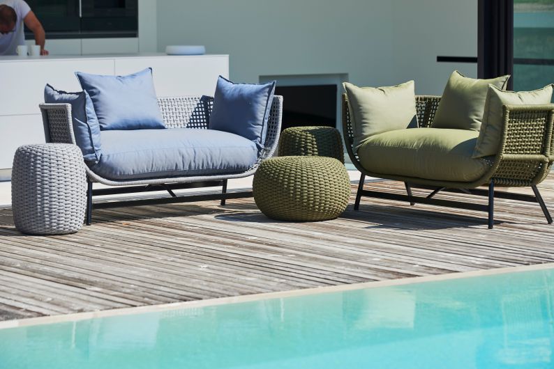 Suka Loungesofa von Jan Kurtz, hellgrau und olivgrün, mit passenden Outdoor-Hockern am Pool.