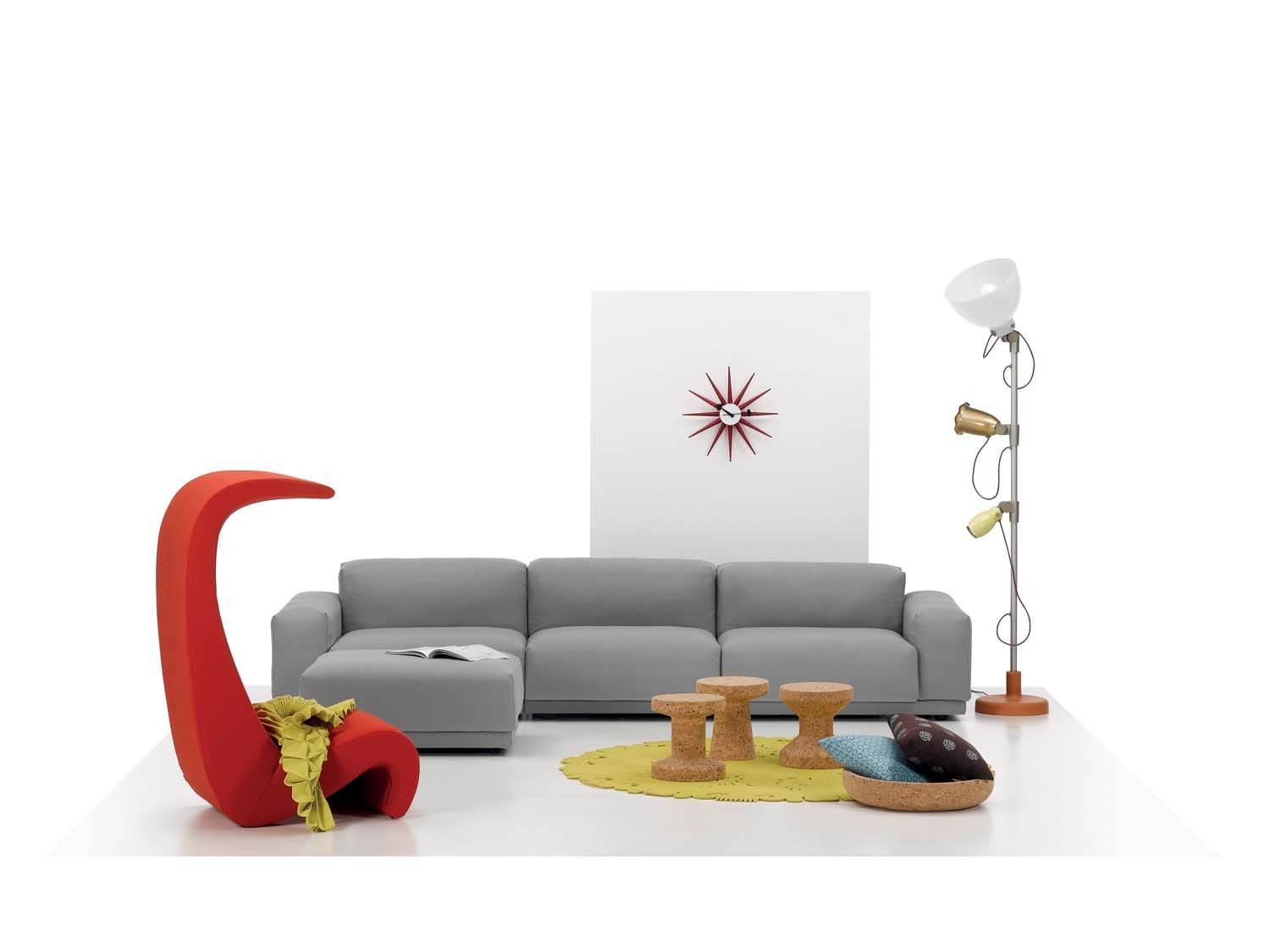 Wohnzimmer-Szene mit roter Sunburst Clock Wanduhr von Vitra an der Wand.