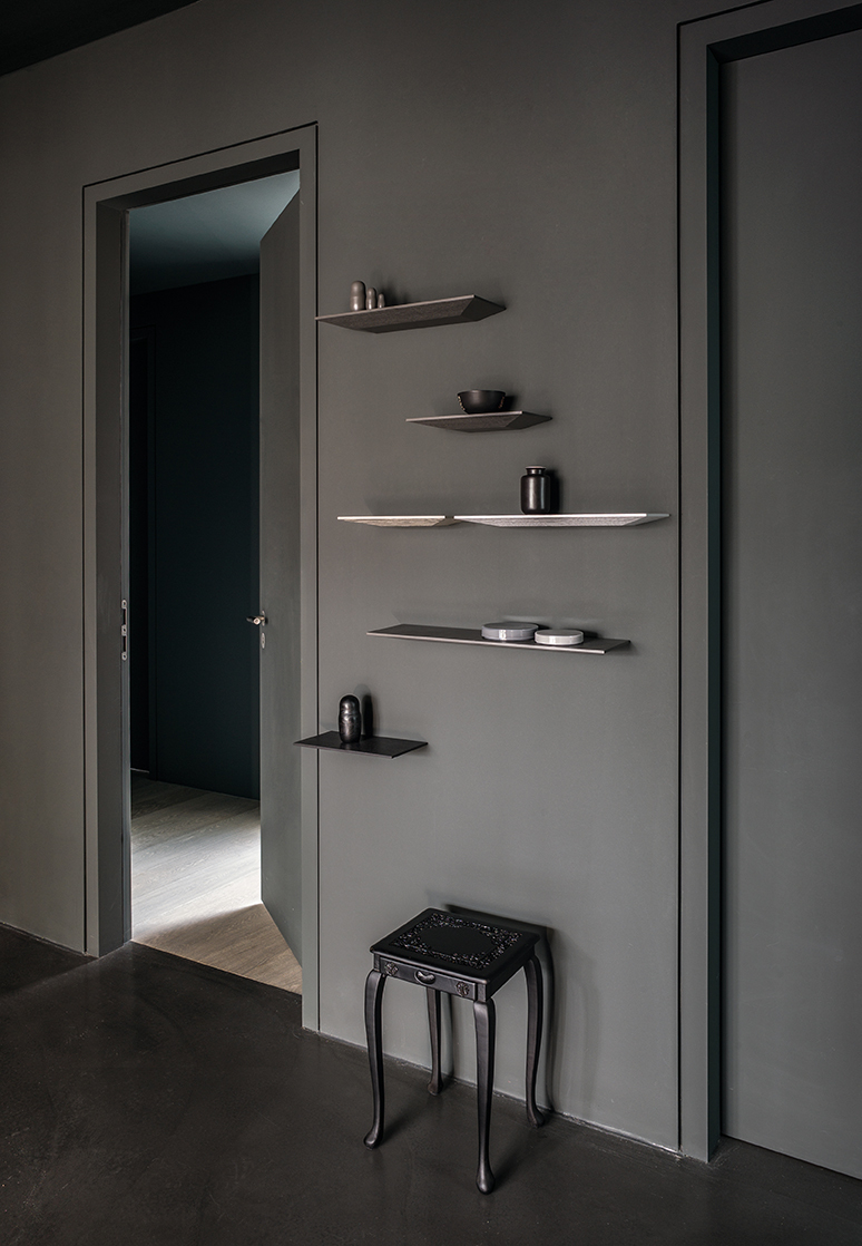 Schönbuch Cut Wandablage in verschiedenen Farben an grauer Wand, kombiniert mit Dekoration. Moderne Wandregale.