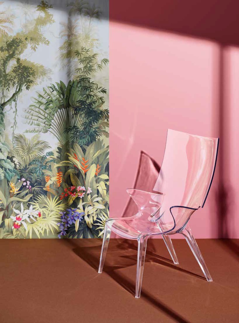 Uncle Jim Sessel von Kartell, transparenter Design Stuhl aus Kunststoff vor rosa Wand und Dschungeltapete.