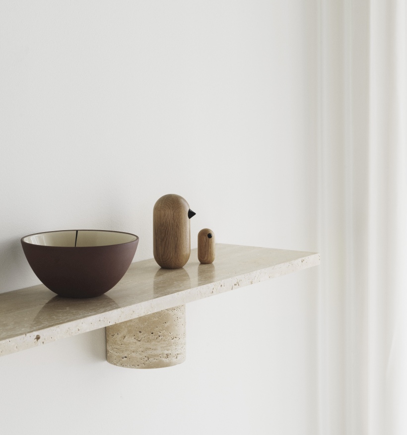 Sten Regal von Normann Copenhagen: Wandregal aus Travertin mit Schale und Holzfiguren.