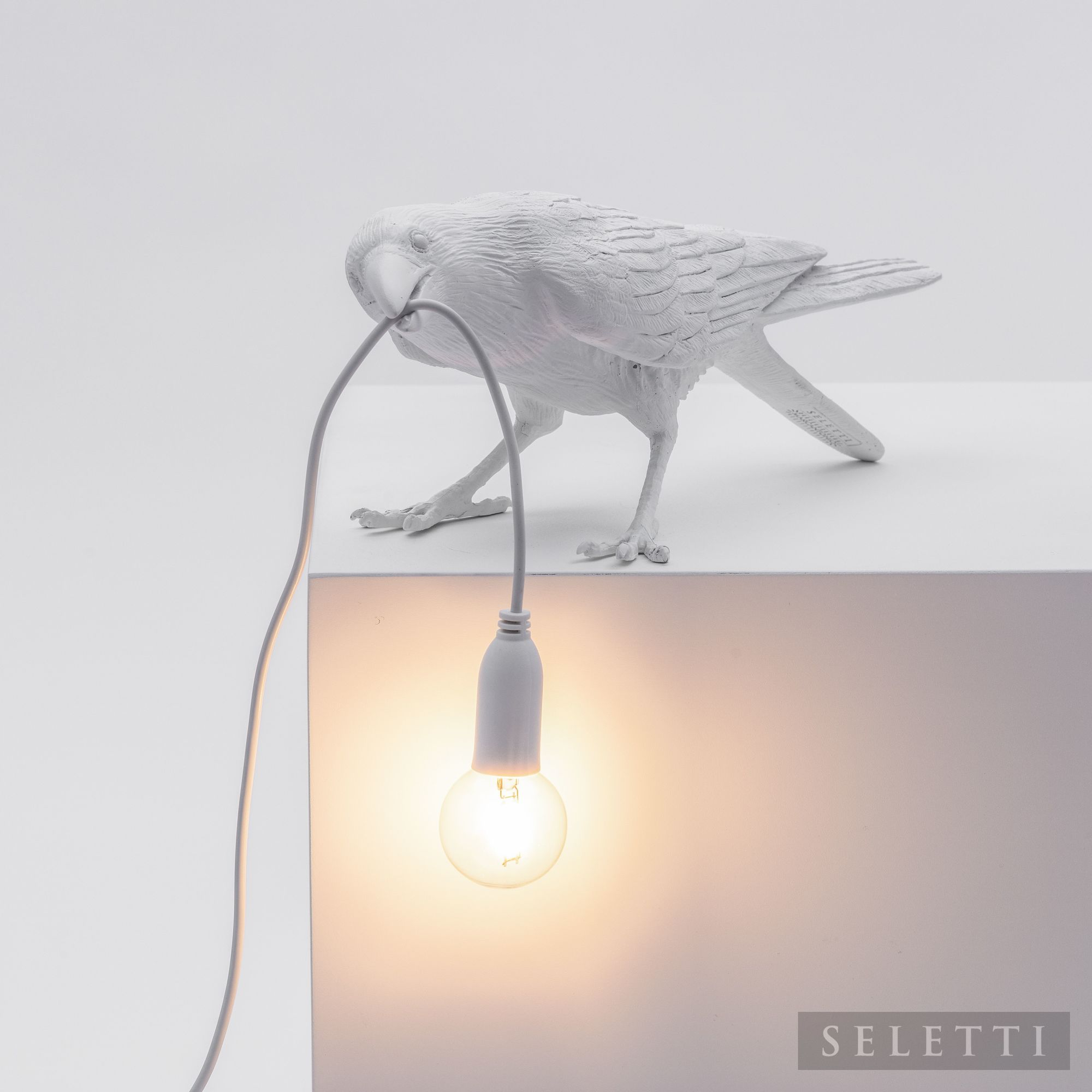 Weiße Bird Lamp Playing Leuchte von Seletti: Vogel hält Kabel mit Glühbirne im Schnabel.