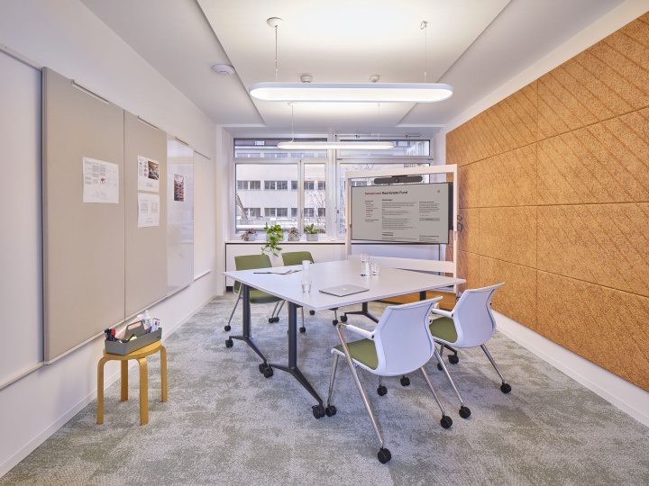 Besprechungsraum mit Vitra MedaMorph Klapptisch, Stühlen und Präsentationsbildschirm für moderne Büros.