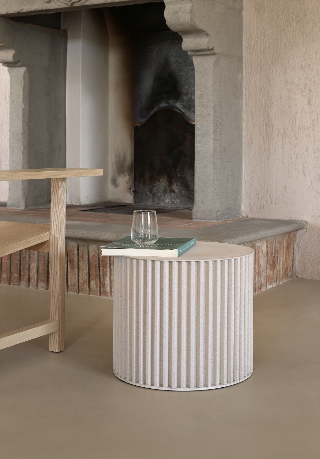 Herclino Couchtisch: Runder Beistelltisch in Weiß mit Buch und Glas, Indoor/Outdoor geeignet.