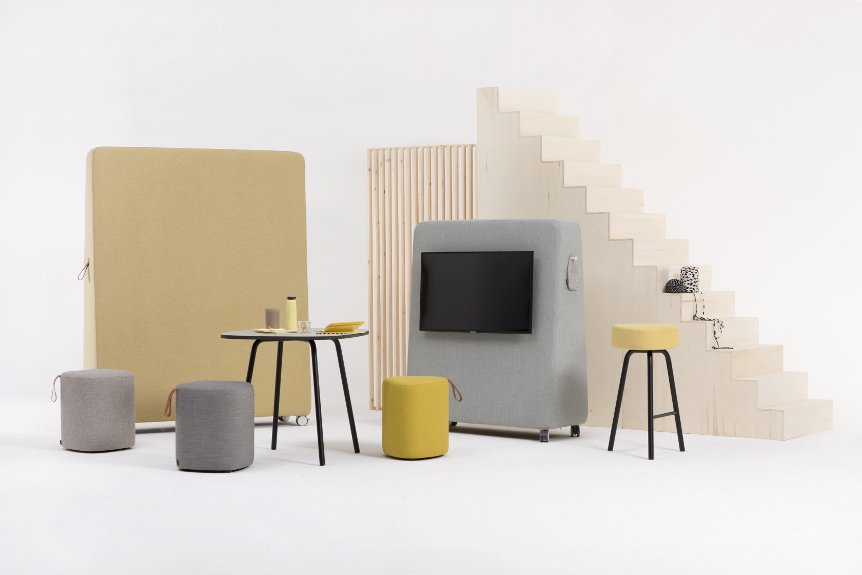 Einrichtung mit Cascando Pully Hocker, Tisch, Stellwänden und Treppe in einem modernen Büro oder Wohnraum.