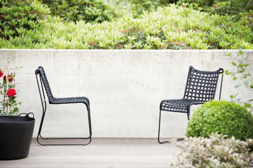 Zwei schwarze Jan Kurtz In/Out Stühle für den Außenbereich auf einer Holzterrasse.