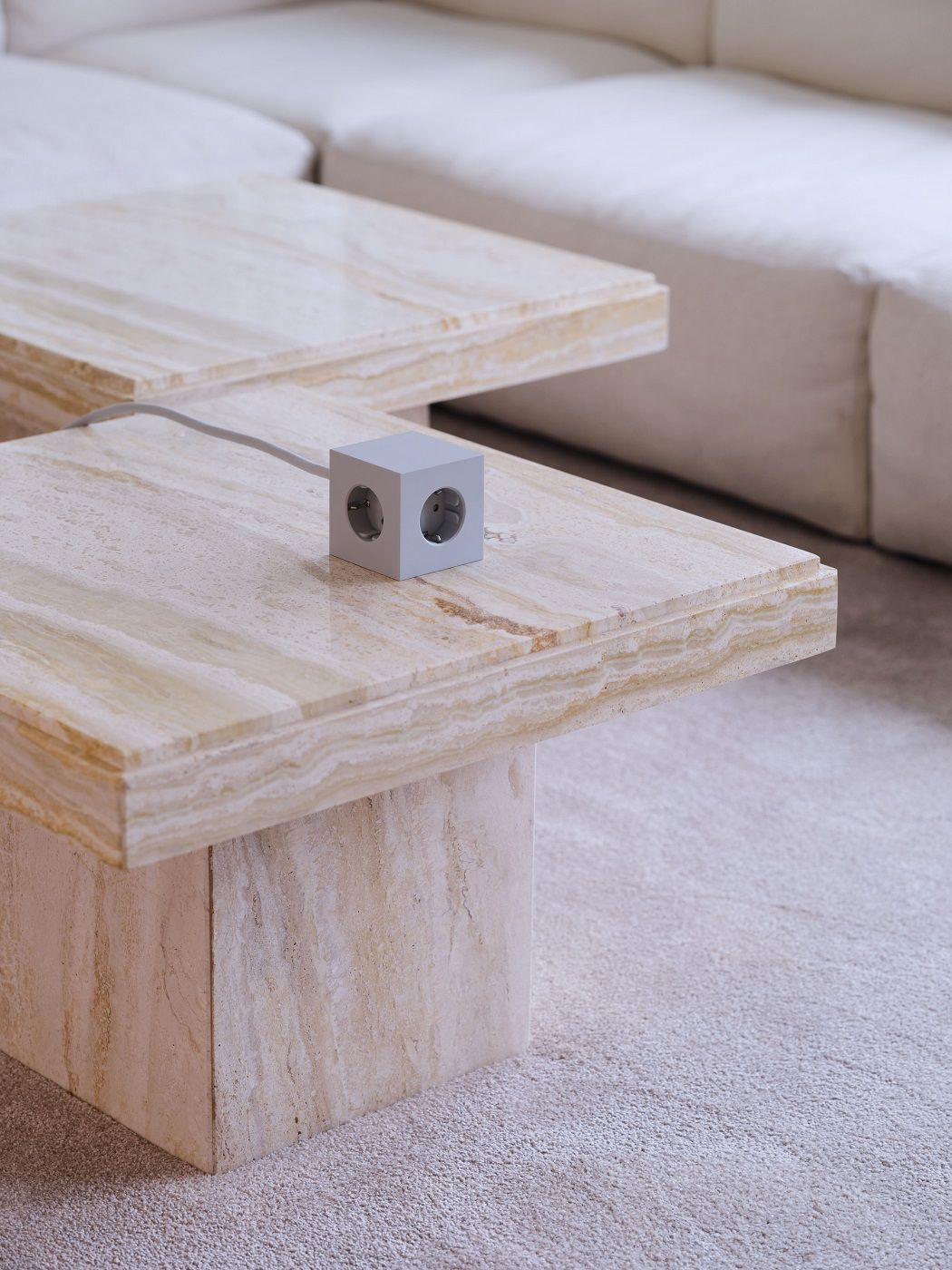 Avolt Square 1 Steckdosenwürfel in Grau auf einem Marmortisch, moderne Stromversorgung.