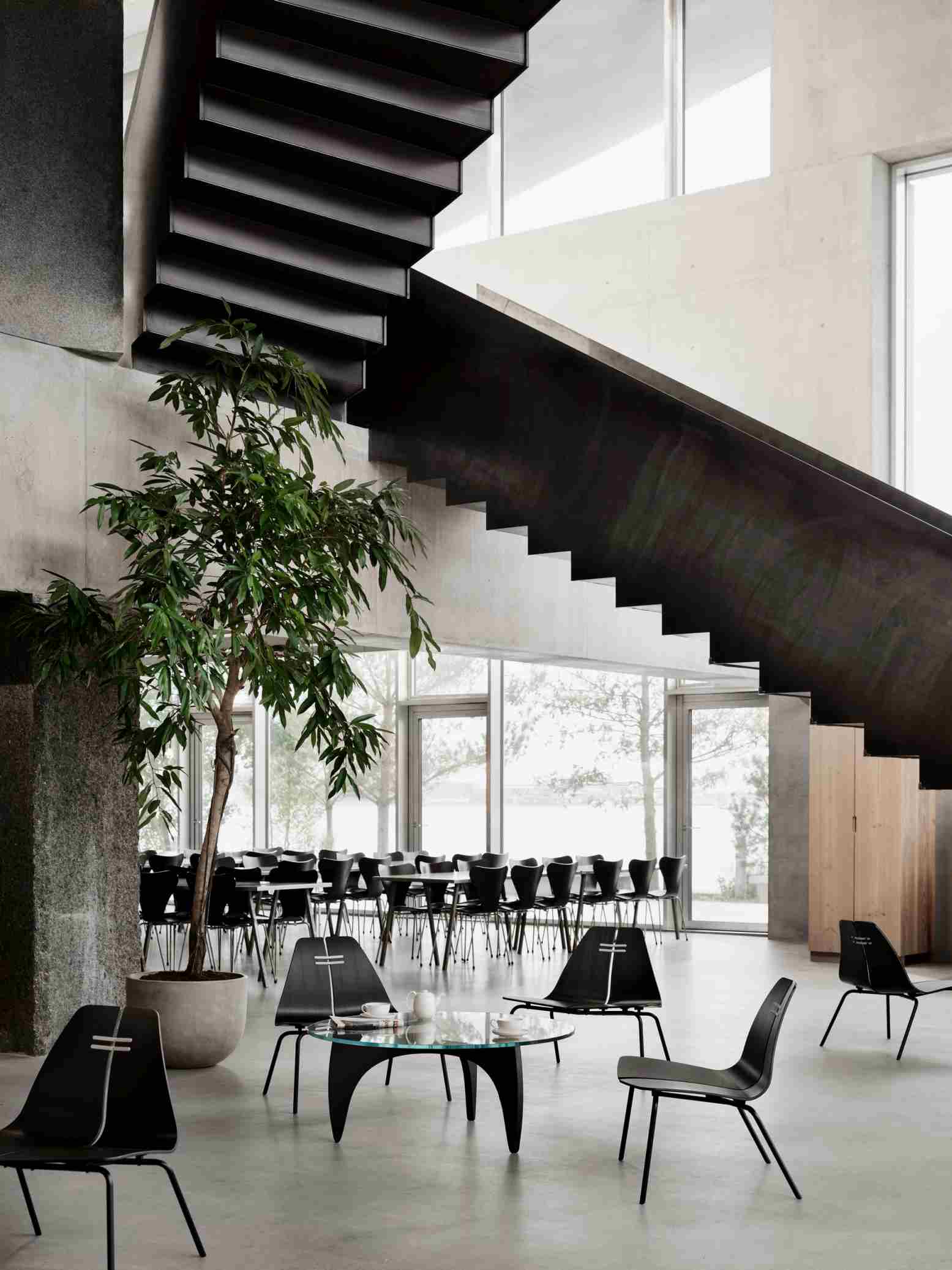 Innenaufnahme mit PK23 Loungesessel von Fritz Hansen, schwarzem Design und minimalistischem Interieur.