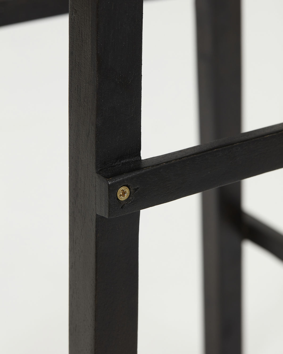 Detailaufnahme vom Laddi Beistelltisch in Schwarz, zeigt die Holzstruktur und Schraubverbindungen des Möbelstücks.