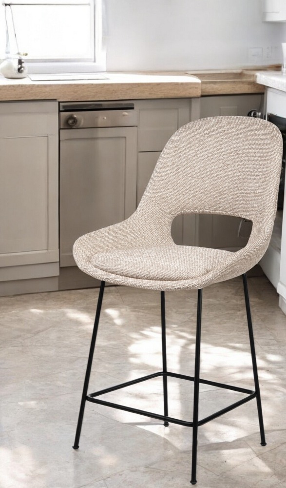 Theia Kitchen Armchair Barstool von Freifrau Manufaktur, niedriger Barhocker mit beigem Stoffbezug und schwarzem Metallgestell.