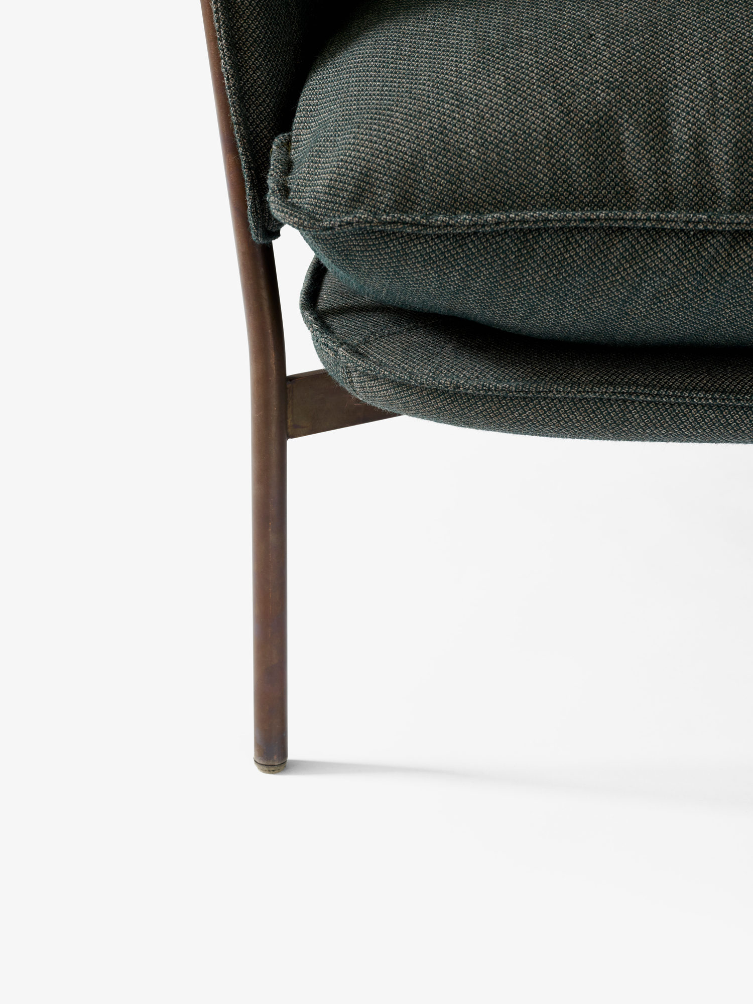 Detailaufnahme: Cloud Sessel von AndTradition mit grünem Stoffbezug und bronzefarbenen Beinen.