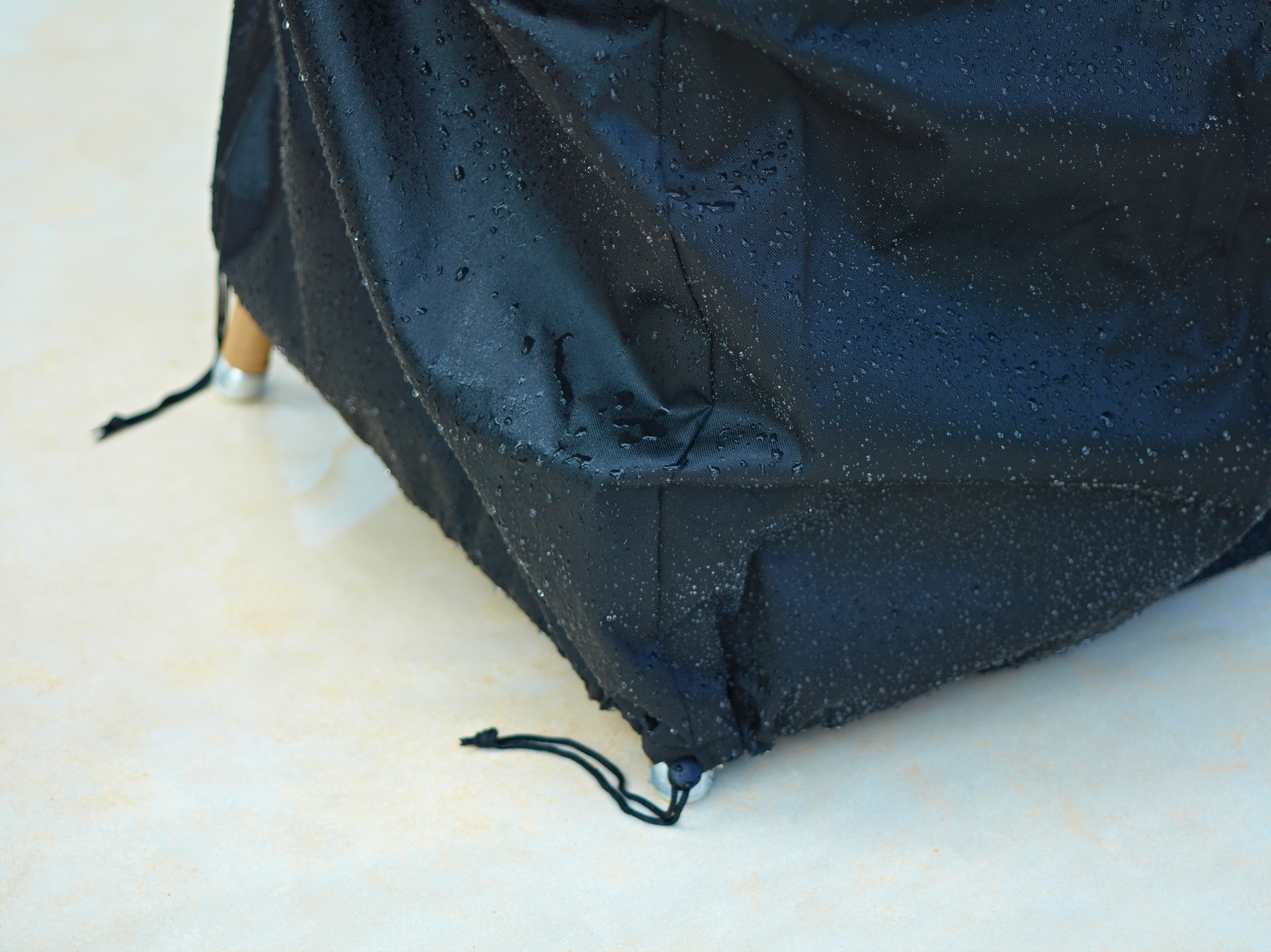 Schwarze Cane-Line Schutzhülle für große Outdoor Sofa Möbel, wasserabweisend mit Regentropfen.