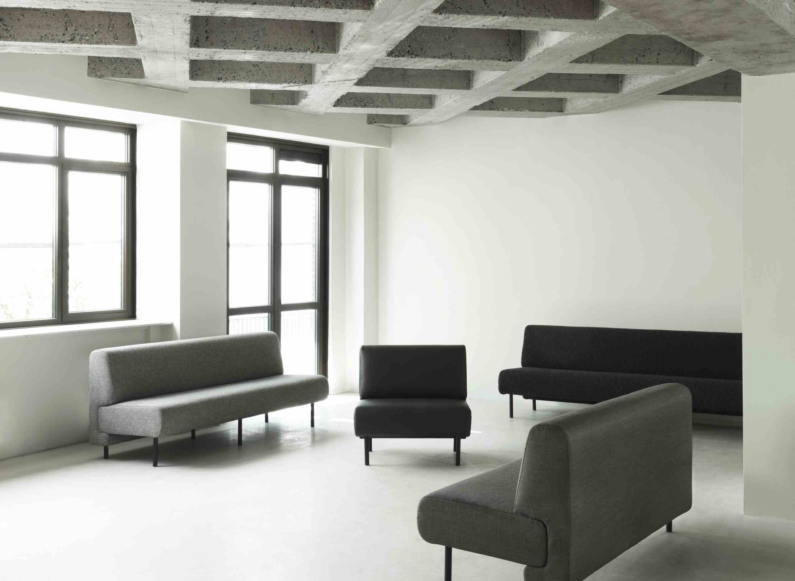 Helles Interieur mit grauem Fram Sofa von Normann Copenhagen und schwarzen Sofas.