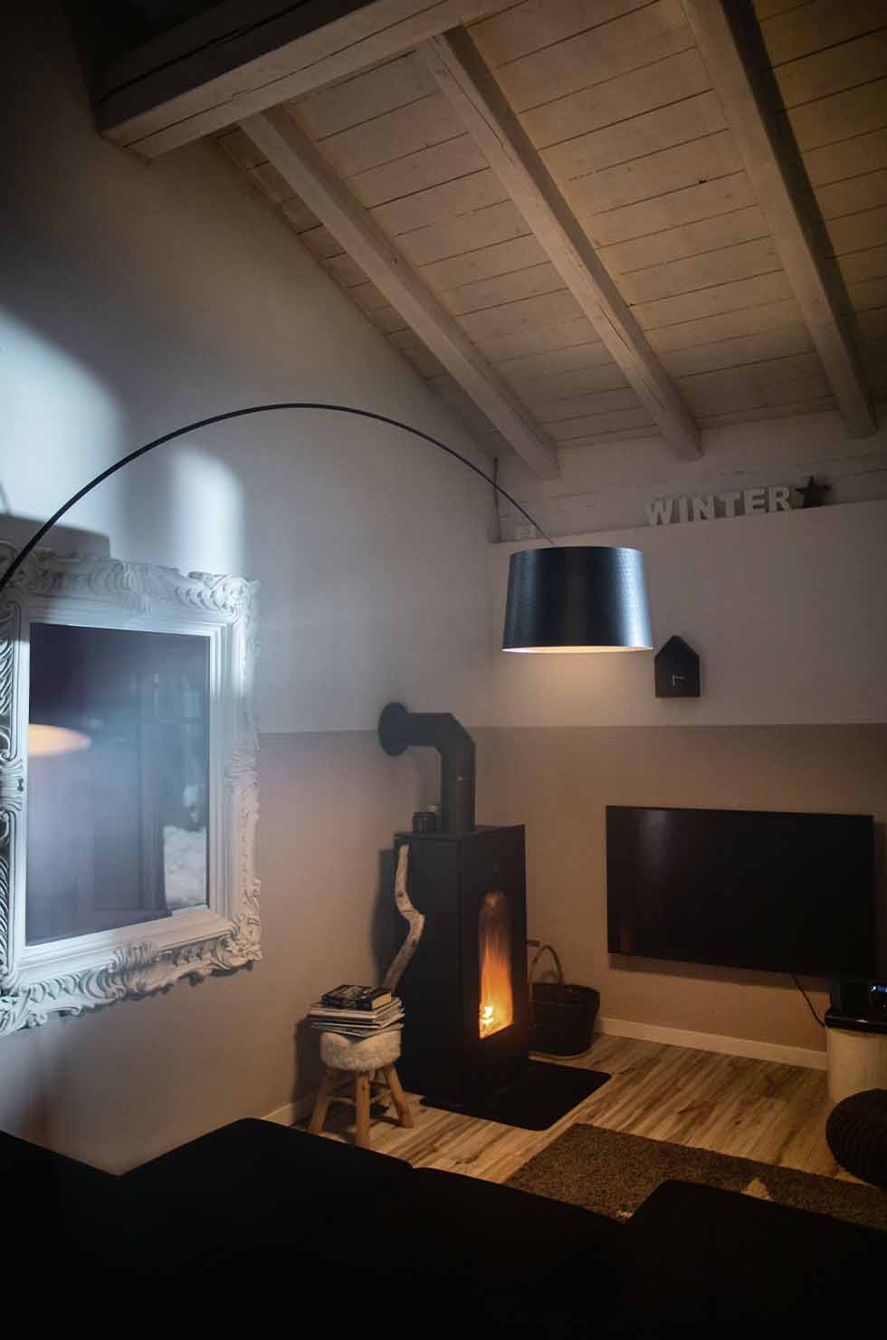 Twiggy Elle Terra LED Stehleuchte von Foscarini in Graphit über einem gemütlichen Wohnzimmer.