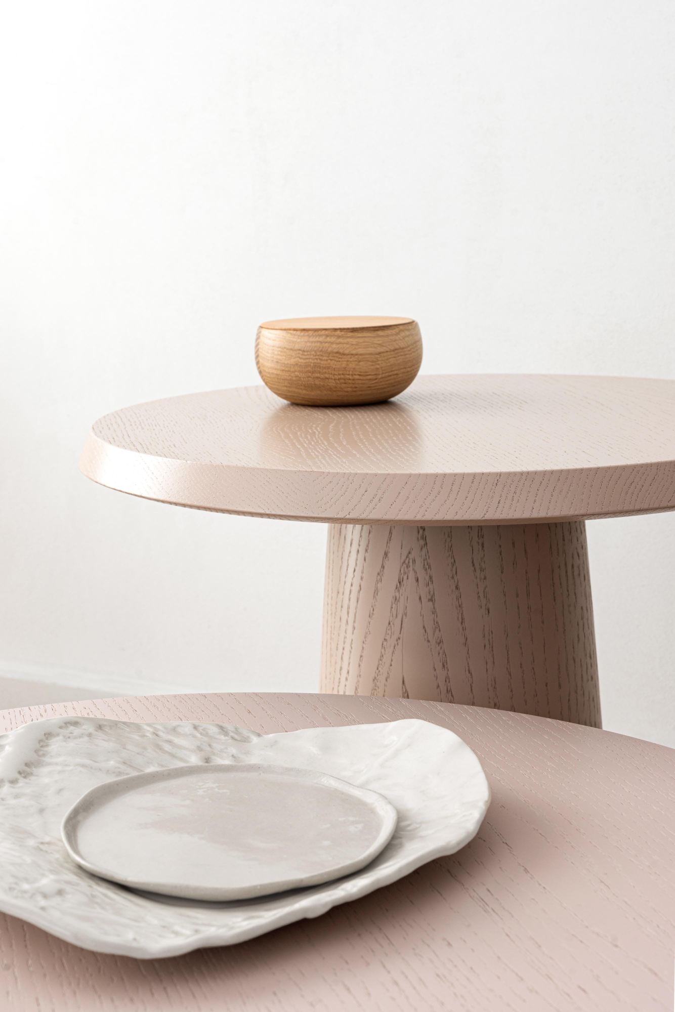 Amanita Beistelltisch von Schönbuch: Runder, rosa Holztisch mit Holzschale und Keramikgeschirr.