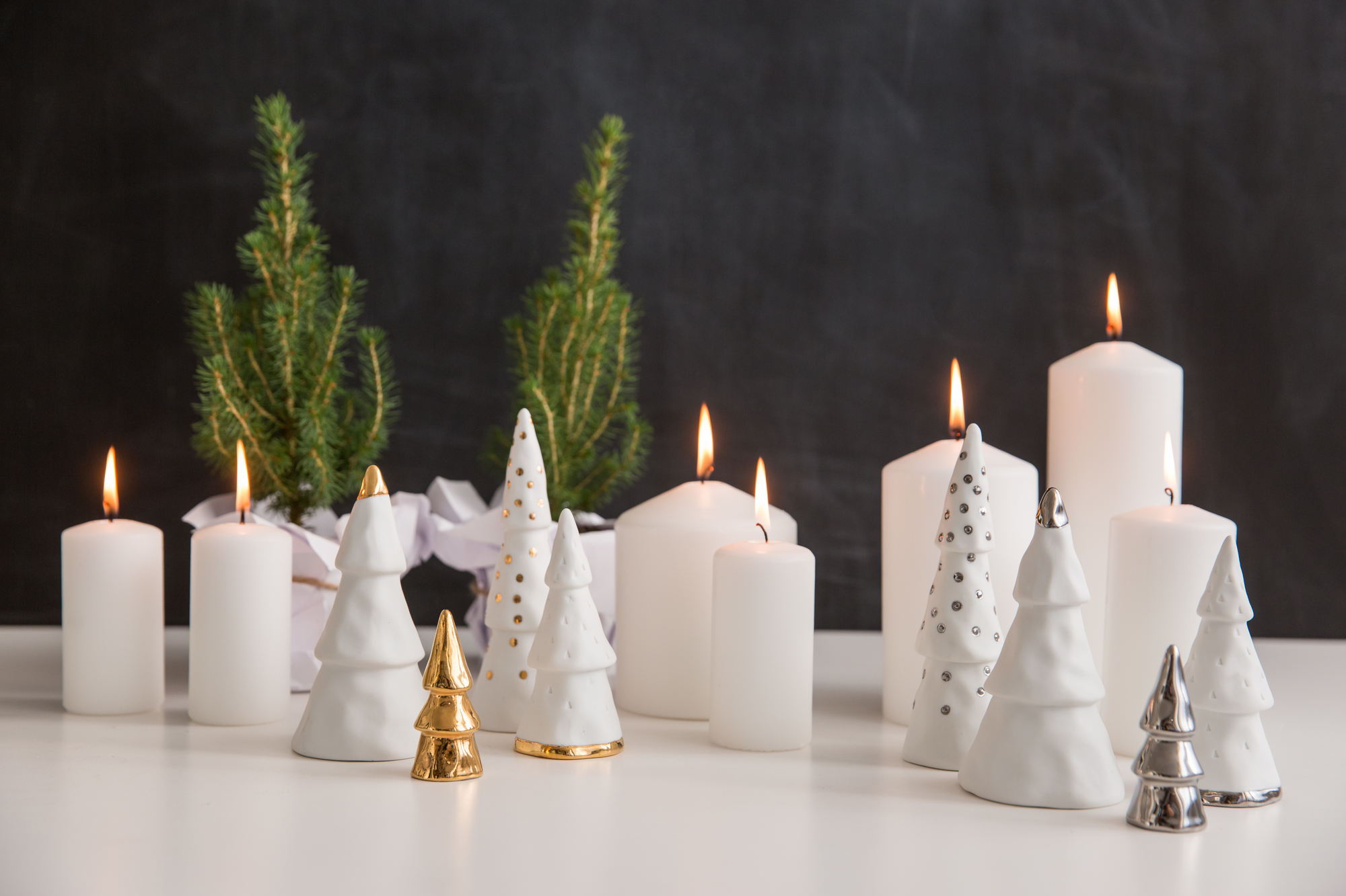 Winterzeit Weihnachtswald Set: Kerzen und Deko-Tannenbäume in Weiß und Gold für festliche Adventszeit.