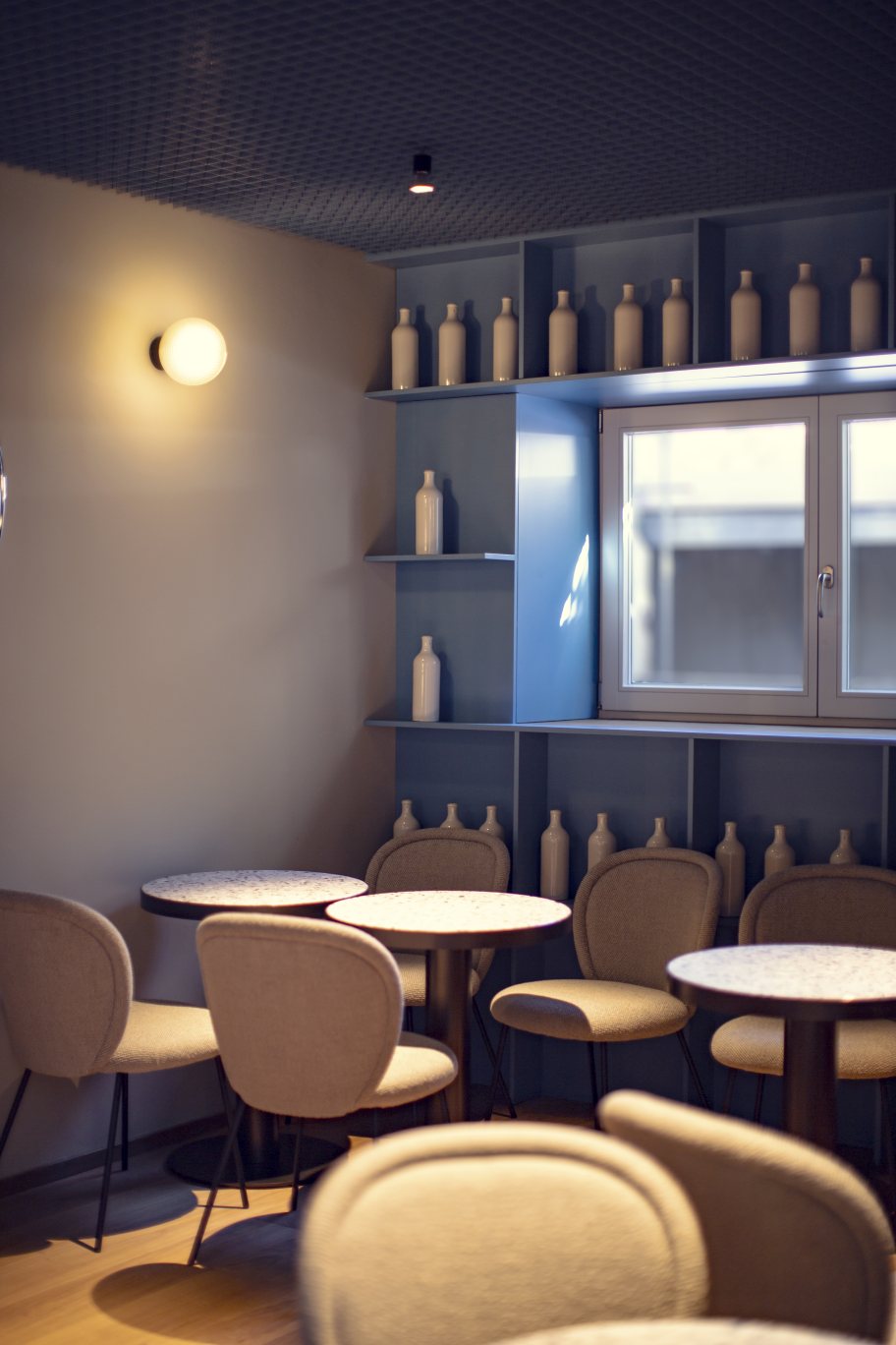 Innenaufnahme mit Stellar Wandleuchte in Aubergine/Schwarz von Pulpo, die eine gemütliche Atmosphäre schafft.