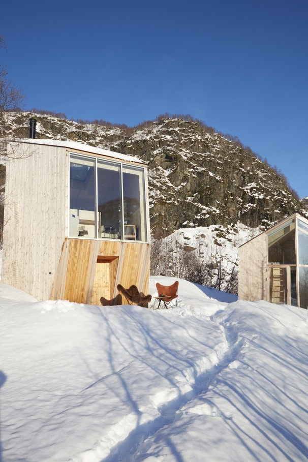 Iceland Mariposa Butterfly Chair Sessel Schaffell Cuero vor Holzhütte im Schnee. Ledersessel mit Schaffell.